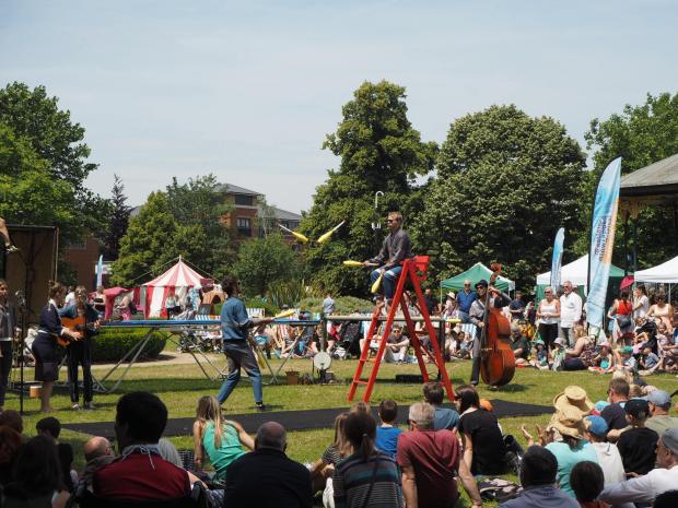Two men juggling in front of a large crowd