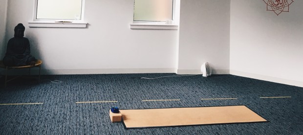 Yoga mat in a studio, with a budda statue