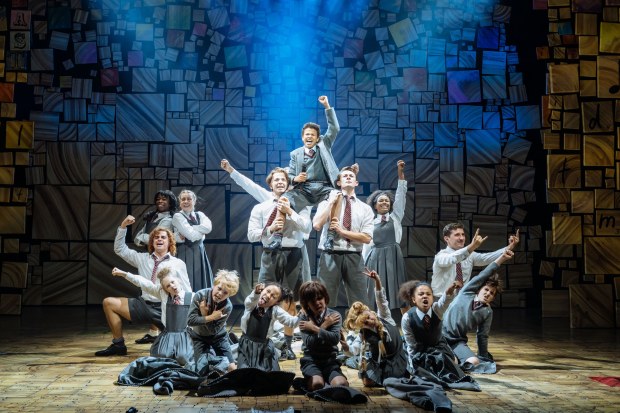 The children's cast of matilda pose on stage