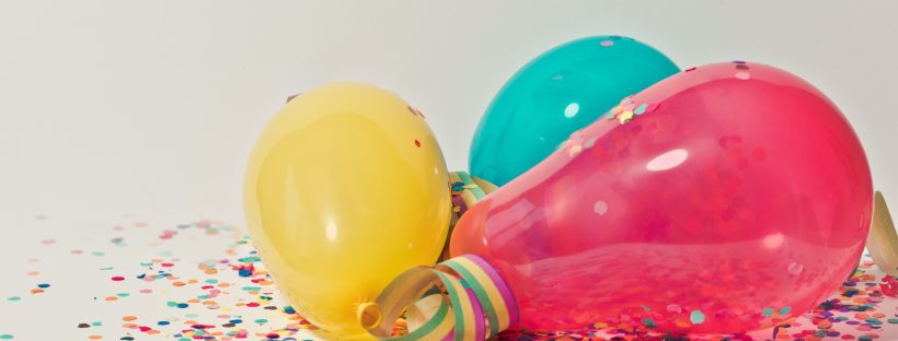 brightly coloured balloons with multicoloured confetti