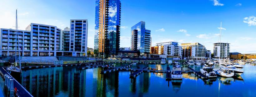modern, tall flats next to a marina with bright blue skies